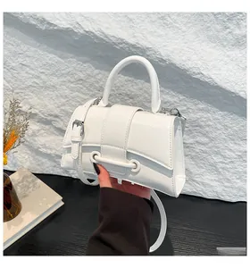 Close-up of white textured hourglass handbag with silver hardware and sleek crossbody strap