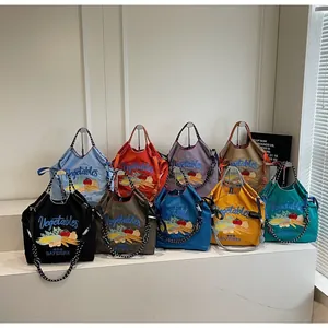 Sacs cabas en nylon colorés avec broderies et bandoulières à pois en présentation