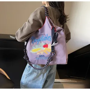 Détail du cabas en nylon violet avec broderie légumes et bandoulière en corde tressée
