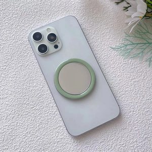 Close-up of mint green magnetic vanity mirror attached to the back of a white smartphone