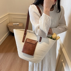 Large woven cream tote bag with brown leather straps and contrast pocket detail