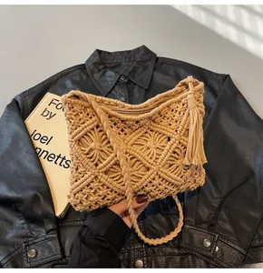 Detailed view of beige handmade woven bucket bag with fringe tassels and geometric texture