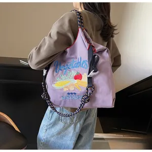 Détail du sac cabas en toile violette avec broderies légumes et bandoulière bleue