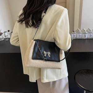 Sac sous le bras chic en paille et cuir noir avec nœud argenté et bandoulière