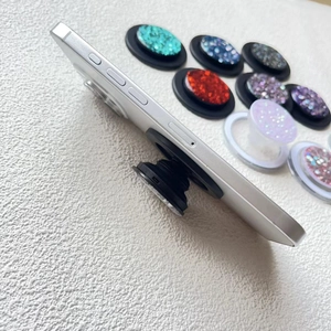 Detail of glitter sequins magnetic phone socket stand expanded on a silver smartphone