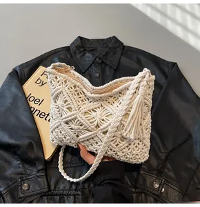 Detailed view of cream hand-woven macrame bucket bag with fringe and zipper closure