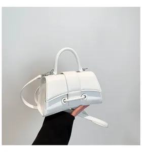 Detailed view of white hourglass handbag showing wrinkled leather texture and curved base