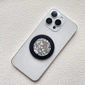 Detail of a round magnetic phone grip featuring silver glitter and a black frame