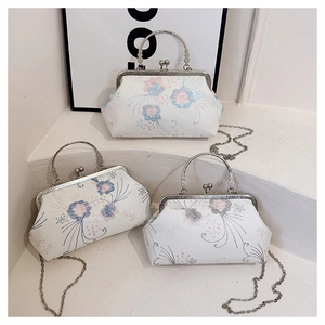 Detail of vintage embroidered floral handbag with silver metal handle and chain strap