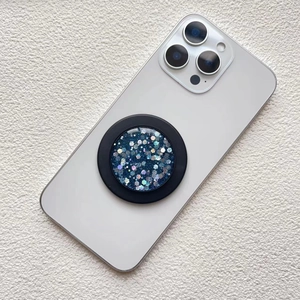 Detail of blue glitter phone grip with star sequence mounted on a white smartphone