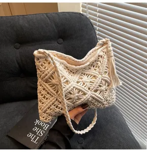 Detail of cream knit bucket bag showing macramé flower texture and tassel accessory