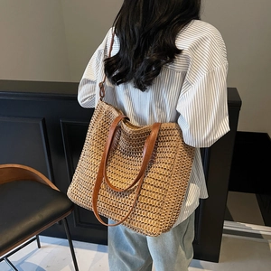 French style woven straw tote bag with brown leather handles in a natural tan finish