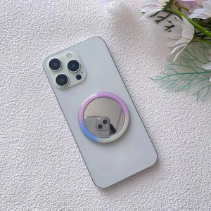 Detail of macaron gradient phone mirror socket with round reflective surface on phone