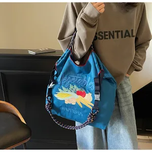 Broderie détaillée de légumes sur un sac cabas en toile bleue avec bandoulière