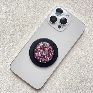 Macro shot of circular magnetic phone socket with pink glitter sequins on black base