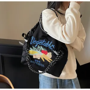 Détail de la broderie de légumes colorés sur le sac de shopping en nylon noir