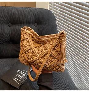 Detailed knit bucket bag showing intricate hollow diamond patterns and fringe tassels