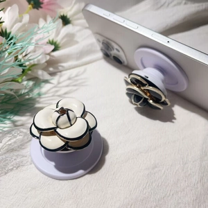 Elegant camellia flower phone socket holder with gold trim and collapsible white base