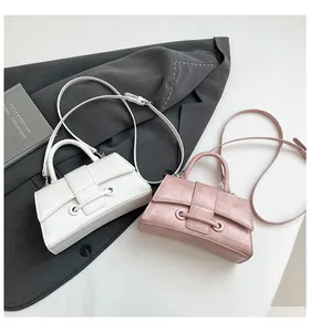 Detailed view of textured pleated leather bags in beige and lavender on grey fabric