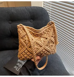 Detail of beige knit bucket bag with hollow diamond pattern and side tassels