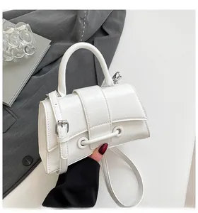 Detail of white hourglass bag with vintage pleated texture and stylish metal buckle