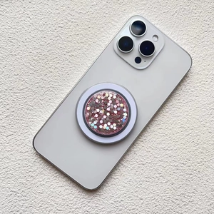 Close-up of pink glitter magnetic phone socket with hexagonal sequins on white background