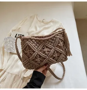Close-up of knit bucket bag with hollow diamond pattern and long side tassels