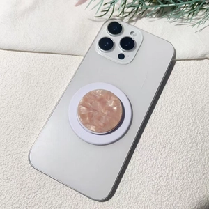 Supporto per telefono in acetato di marmo rosa su iPhone bianco con sfondo decorativo