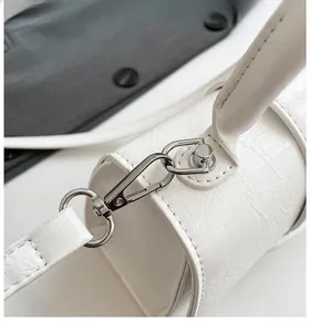 Detailed macro view of white hourglass bag showing cracked leather texture and silver buckle
