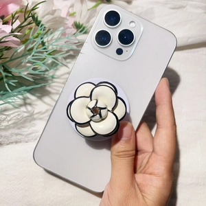 Detail of camellia flower phone socket on a purple smartphone with a 3D relief design