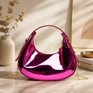 Vue détaillée du sac croissant rose métallisé avec finition brillante et chaîne dorée