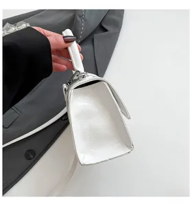 Detail of white hourglass handbag in oil wax leather with silver buckle and thin strap