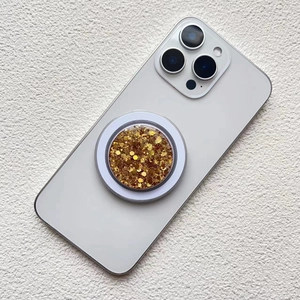 Macro detail of round magnetic phone socket with sparkling gold glitter and resin finish