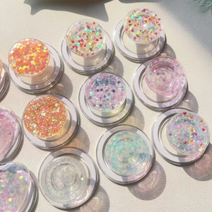 Flat lay macro of transparent phone grips filled with colorful heart-shaped glitter sequins