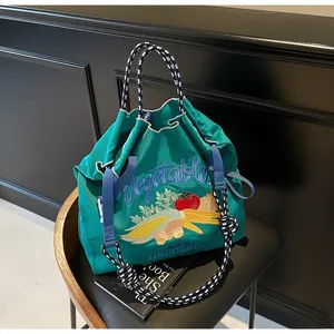 Détail du sac cabas en toile verte avec broderie détaillée de motifs de légumes