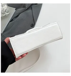 Detailed view of the bottom structure and textured leather of the white hourglass handbag
