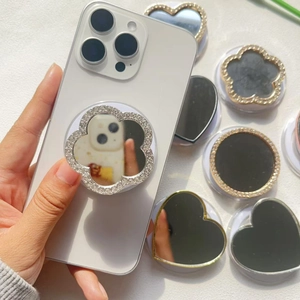 Close-up of sparkling rhinestone square mirror phone grip being held on a smartphone