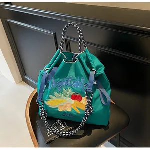 Détail du sac en toile verte avec broderie Vegetable bleue et poignée en corde tressée