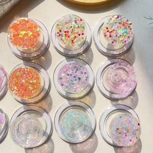 Collage of colorful heart-shaped glitter and sequins inside round phone grip sockets