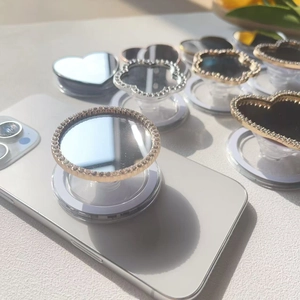 Macro detail of luxury rhinestone square mirror phone grip with retractable folding design