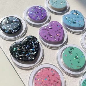 Close-up of glitter-filled heart and round magnetic phone grips in macaron pastel colors