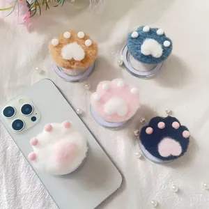 Detail of plush cat paw phone sockets in five colors on a white textured background