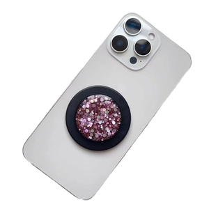 Pink glitter magnetic phone grip and expandable stand on white smartphone back
