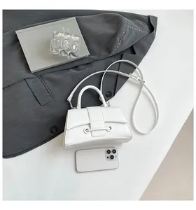 White hourglass handbag next to a smartphone showing size reference and texture