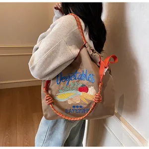 Détail du sac en toile kaki avec broderie de légumes et bandoulière en corde épaisse