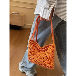 Orange handmade knit bucket bag with macrame pattern and bohemian fringe details