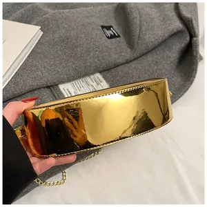 Macro shot of metallic gold mini bag showing smooth mirror finish and stitching detail