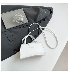 Detailed view of the white wrinkled leather trapezoid handbag with detachable shoulder strap