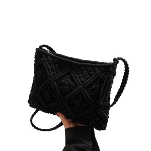 Black knit bucket bag with woven diamond pattern and decorative side tassels