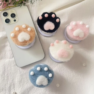 Macro detail of plush cat paw phone sockets in five colors with soft felt texture